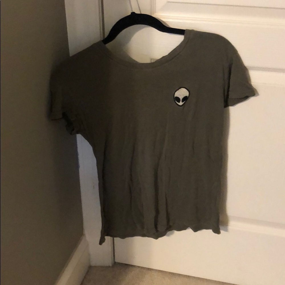 Army green shirt with alien on left of chest.